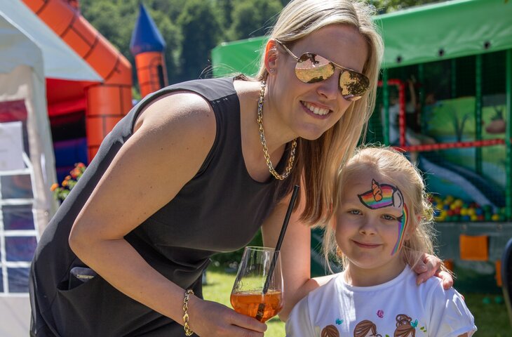 Mutter mit ihrer Tochter mit Kinderschminken im Gesicht auf dem Sommerfest des Hotel Deimann